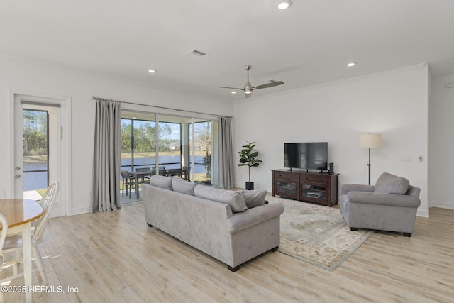 living room featuring ornamental molding, ceiling fan, and light wood-type flooring