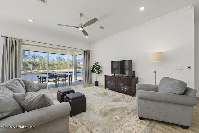 living room featuring ornamental molding, ceiling fan, and light hardwood / wood-style flooring