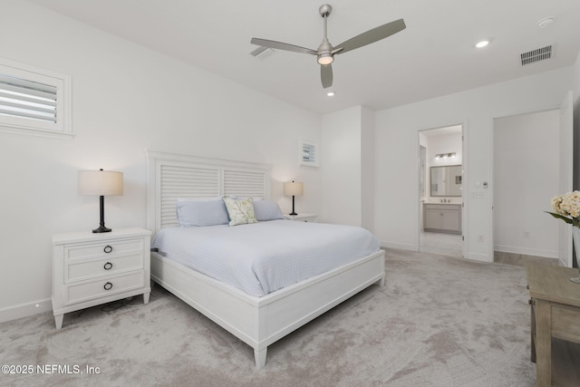 bedroom featuring light carpet, ceiling fan, and ensuite bathroom