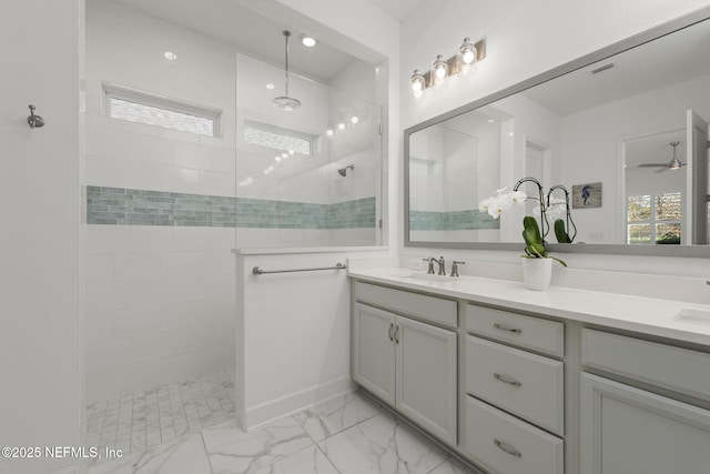 bathroom featuring vanity, ceiling fan, and a tile shower