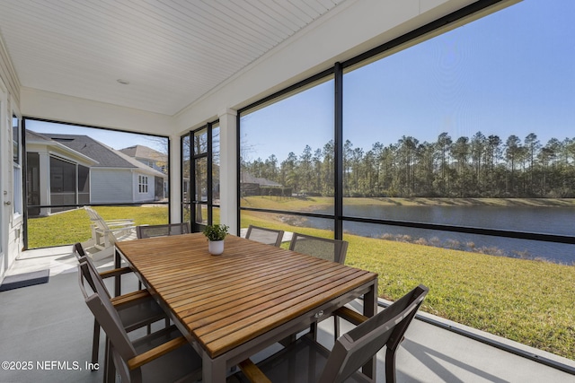 sunroom featuring a water view