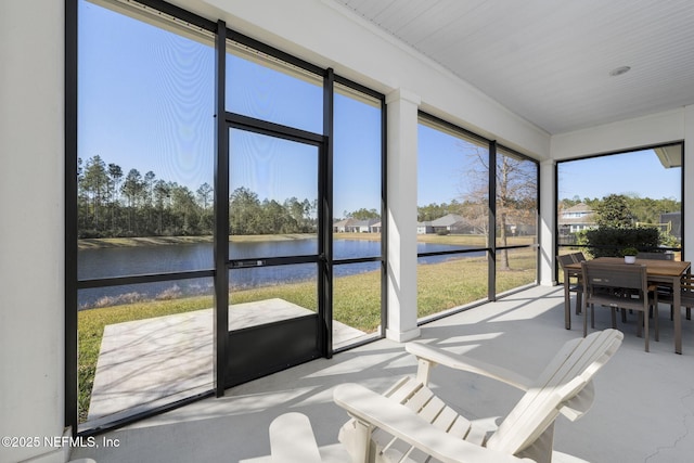 sunroom featuring a water view