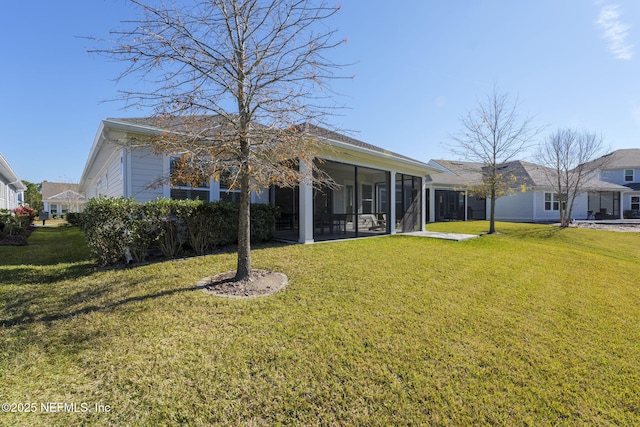 back of house featuring a yard and a sunroom