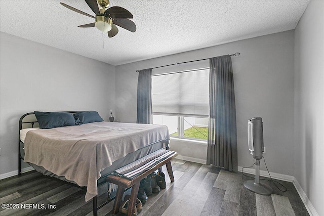 bedroom featuring ceiling fan, dark hardwood / wood-style floors, and a textured ceiling