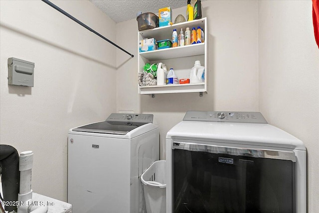 laundry room with washer and dryer and a textured ceiling