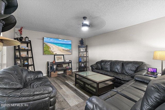 living room with ceiling fan, wood-type flooring, and a textured ceiling