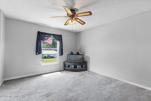 empty room featuring ceiling fan, a textured ceiling, and carpet flooring