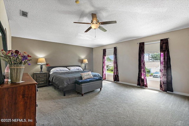 carpeted bedroom featuring ceiling fan and a textured ceiling