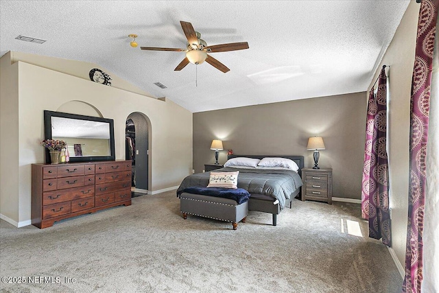 carpeted bedroom with lofted ceiling, ceiling fan, and a textured ceiling