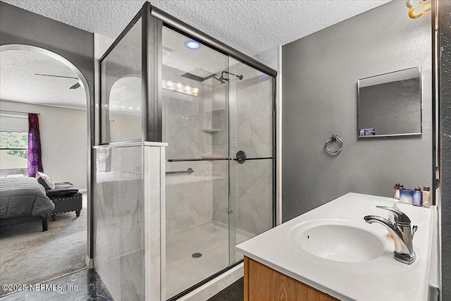 bathroom with vanity, a textured ceiling, and walk in shower