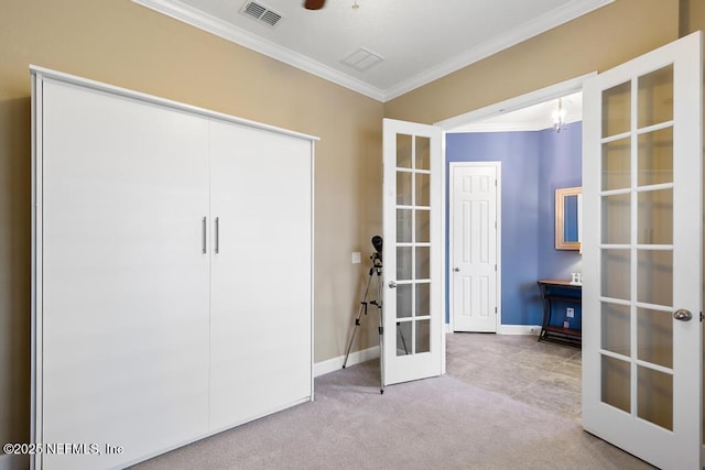 unfurnished bedroom featuring french doors, a closet, ornamental molding, and light carpet