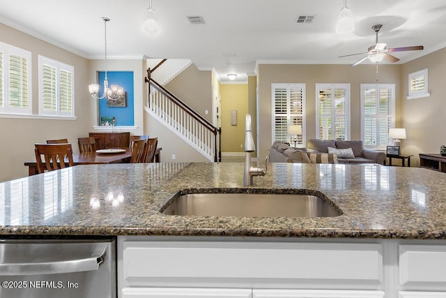 kitchen with hanging light fixtures, sink, and dark stone counters