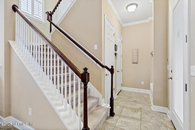 entrance foyer with crown molding and light tile patterned flooring