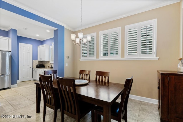 dining area featuring crown molding, light tile patterned floors, and an inviting chandelier