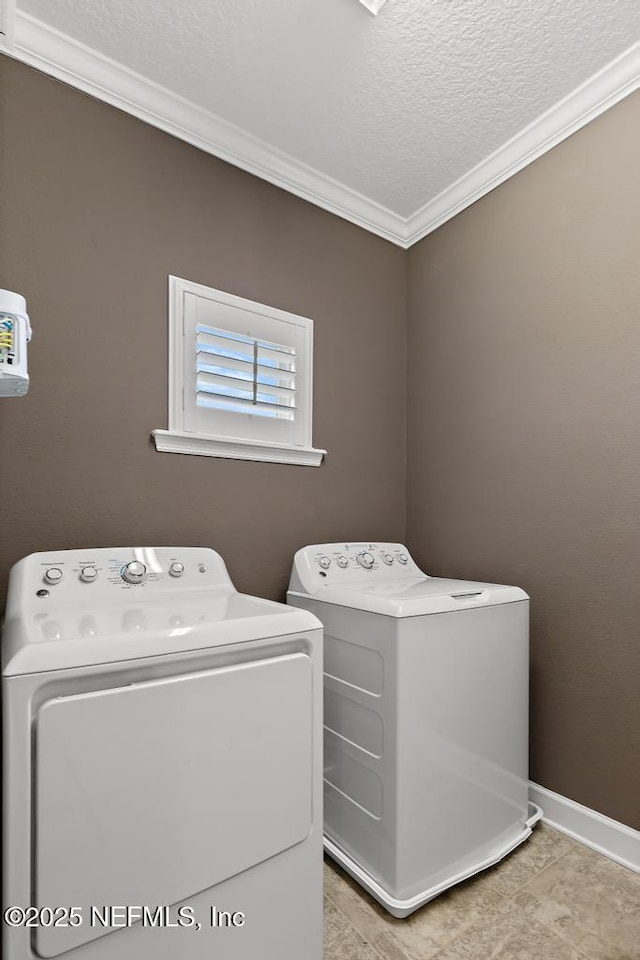 laundry room with crown molding, a textured ceiling, and washer and clothes dryer