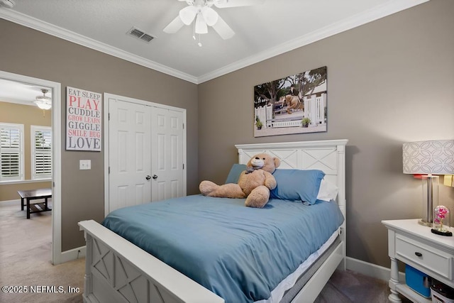 bedroom with ornamental molding, carpet flooring, ceiling fan, and a closet