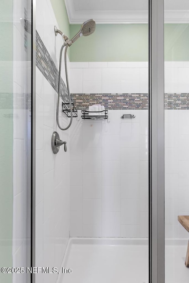 bathroom with ornamental molding and a shower with door