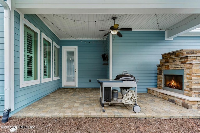 view of patio featuring ceiling fan and an outdoor stone fireplace