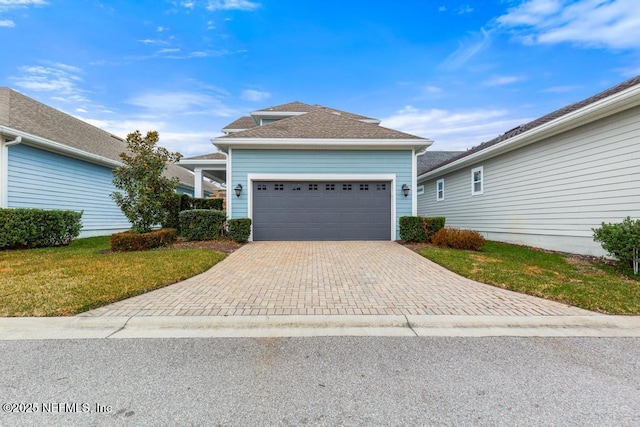 view of front of house with a garage and a front lawn