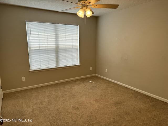 carpeted spare room featuring ceiling fan and a textured ceiling