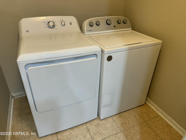 clothes washing area featuring washing machine and clothes dryer and light tile patterned flooring