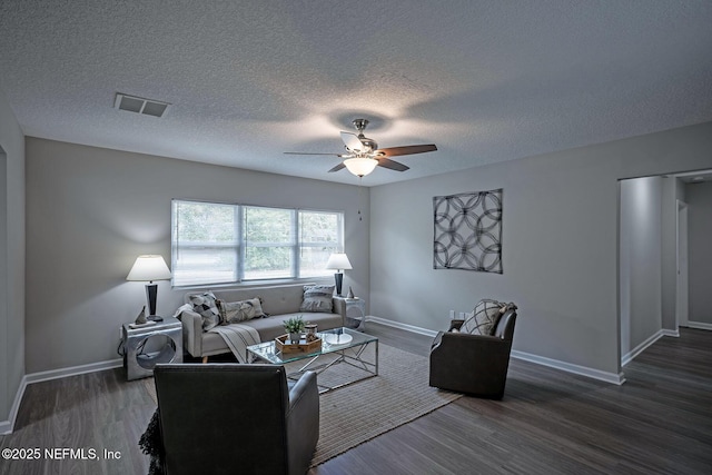 living room with ceiling fan, dark hardwood / wood-style floors, and a textured ceiling