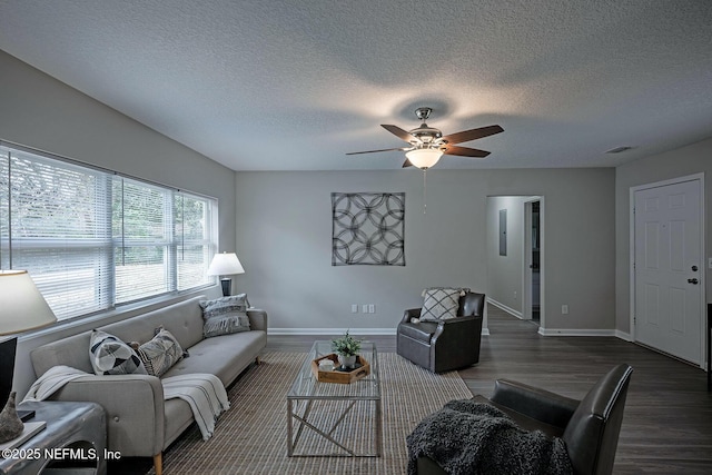 living room featuring a textured ceiling, dark hardwood / wood-style floors, and ceiling fan