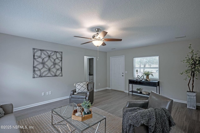 living room featuring dark hardwood / wood-style floors, a textured ceiling, and ceiling fan