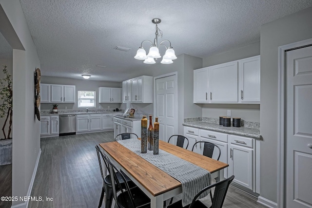 dining room featuring dark hardwood / wood-style flooring, sink, a textured ceiling, and an inviting chandelier