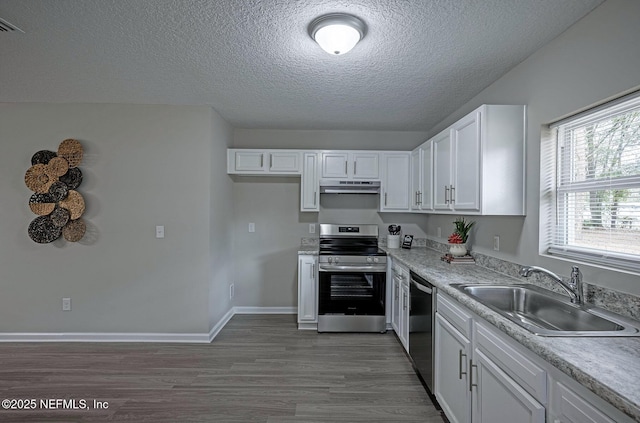 kitchen featuring sink, stainless steel range with electric cooktop, dishwasher, hardwood / wood-style floors, and white cabinets