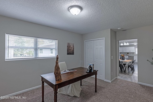 office space featuring light colored carpet and a textured ceiling