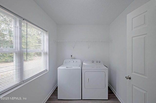 clothes washing area with separate washer and dryer, dark hardwood / wood-style floors, and a textured ceiling