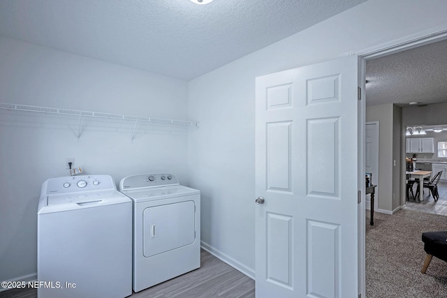 clothes washing area featuring independent washer and dryer and a textured ceiling