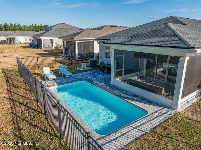 view of swimming pool featuring central AC, a patio area, a sunroom, and a lawn