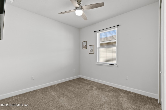 carpeted spare room featuring ceiling fan