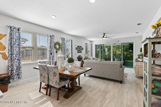 dining space featuring ceiling fan, a textured ceiling, and light wood-type flooring