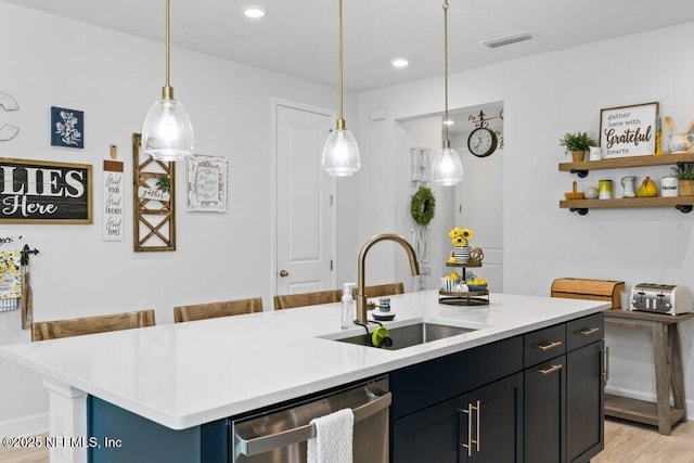 kitchen with a kitchen island with sink, sink, pendant lighting, and dishwasher