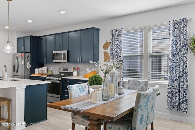 kitchen featuring sink, decorative light fixtures, a healthy amount of sunlight, and appliances with stainless steel finishes