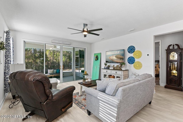 living room with ceiling fan and light hardwood / wood-style flooring