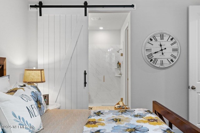 bedroom featuring ensuite bathroom and a barn door