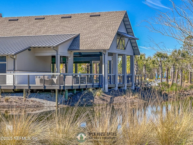 back of property with a deck with water view