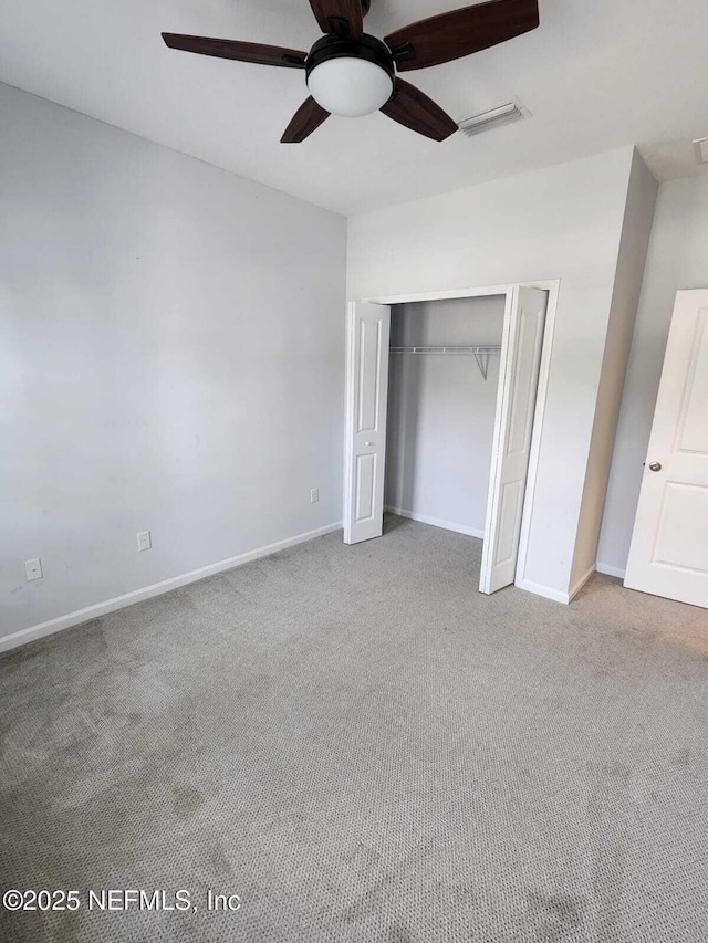 unfurnished bedroom with light carpet, a closet, and ceiling fan