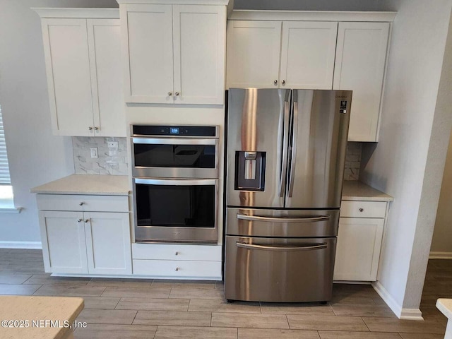 kitchen featuring white cabinetry, appliances with stainless steel finishes, and backsplash