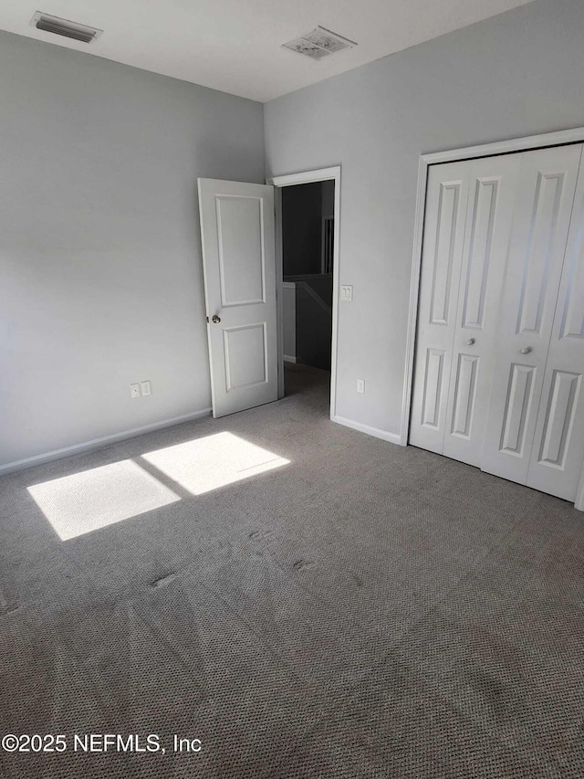 unfurnished bedroom featuring carpet floors and a closet