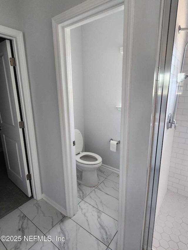 bathroom featuring an enclosed shower and toilet