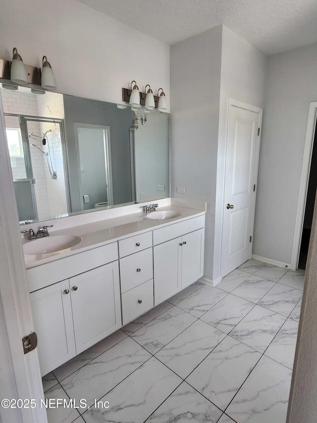 bathroom featuring vanity, toilet, a shower with door, and a textured ceiling