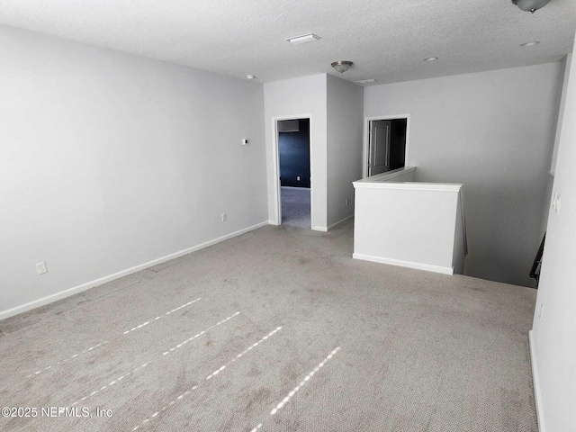 carpeted spare room featuring a textured ceiling