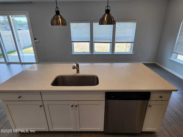 kitchen with pendant lighting, stainless steel dishwasher, sink, and white cabinets