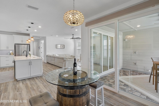 dining space with light hardwood / wood-style flooring and ceiling fan