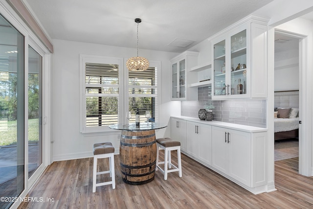 bar featuring white cabinetry and light hardwood / wood-style floors